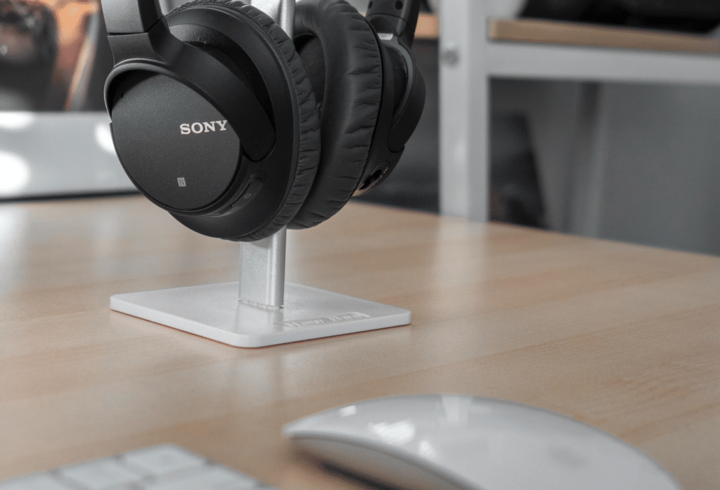 headset hanging near apple mouse and keyboard